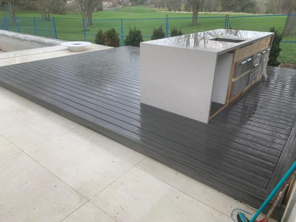 Outdoor kitchen on composite deck with sink and stovetop
